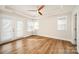 Bright bedroom with tray ceiling, wood-look floors, double doors to balcony, and large windows at 604 Amalfi Dr, Davidson, NC 28036