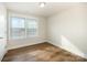 Bedroom with wood-look floors, window with blinds, and white trim at 604 Amalfi Dr, Davidson, NC 28036