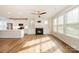 Open-concept living room with a fireplace, hardwood floors, and a view into the modern kitchen at 604 Amalfi Dr, Davidson, NC 28036