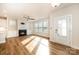 Bright and airy living room with a cozy fireplace, hardwood floors, and a wall of windows at 604 Amalfi Dr, Davidson, NC 28036