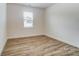 Empty bedroom featuring wood floors, a window with coverings, and electrical outlets at 6911 Fauna Dr # 60, Charlotte, NC 28215