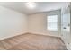 Bright, carpeted bedroom with a window and neutral walls, offering a calm space at 6911 Fauna Dr # 60, Charlotte, NC 28215