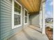 Inviting covered porch with gray siding, wood ceiling, and decorative white columns at 6911 Fauna Dr # 60, Charlotte, NC 28215