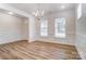 An empty dining room is painted white with hardwood floors and has modern paneling and lots of light at 6911 Fauna Dr # 60, Charlotte, NC 28215