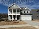 Two-story house with gray siding, a balcony, and a two-car garage at 6911 Fauna Dr # 60, Charlotte, NC 28215