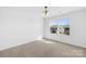 Bright bedroom with neutral carpet, large windows, and modern lighting fixture at 7405 Bosson Sw St, Concord, NC 28025