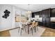 Bright dining room featuring a wooden table and six chairs,dark cabinetry and hardwood floors at 7405 Bosson Sw St, Concord, NC 28025