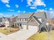 Two-story house with stone accents, three-car garage, and landscaped yard at 7405 Bosson Sw St, Concord, NC 28025