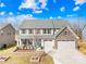 Two-story house with stone accents, three-car garage, and landscaped yard at 7405 Bosson Sw St, Concord, NC 28025