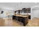 Modern kitchen with dark cabinetry, granite countertops, and an island with seating at 7405 Bosson Sw St, Concord, NC 28025