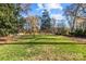 Spacious grassy backyard with mature trees and a partially wooded area at 835 Museum Dr, Charlotte, NC 28207