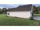 Side view of the home showing a well-maintained lawn, landscaping, and a two-car garage at 000 Ridgecrest Rd # 10, Locust, NC 28097