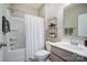 Well-lit bathroom with a shower over tub, double shelves, and a gray vanity at 128 Shay Crossing Rd, Salisbury, NC 28146