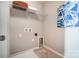 Bright laundry room features convenient shelf space, modern artwork, and tile flooring at 128 Shay Crossing Rd, Salisbury, NC 28146