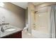 Bathroom featuring a granite countertop, wood cabinet, and shower with white tile surround at 128 Steinbeck Way # E, Mooresville, NC 28117
