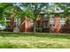 Brick townhome exterior with well-maintained lawn, mature trees and steps leading up to the front door at 128 Steinbeck Way # E, Mooresville, NC 28117
