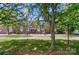 Exterior shot of the brick townhome complex with well-maintained lawn, mature trees and lampposts at 128 Steinbeck Way # E, Mooresville, NC 28117