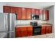 Modern kitchen showcases rich wood cabinetry, granite countertops, and stainless steel appliances at 128 Steinbeck Way # E, Mooresville, NC 28117