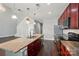 Bright, open kitchen with an island, stainless steel appliances, and a view to the living area with soaring ceilings at 128 Steinbeck Way # E, Mooresville, NC 28117