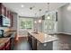 Bright, open kitchen with an island, stainless steel appliances, and a view to the living area with soaring ceilings at 128 Steinbeck Way # E, Mooresville, NC 28117