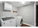 Laundry room with washer and dryer and overhead cabinets at 128 Steinbeck Way # E, Mooresville, NC 28117