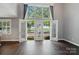 Living room features hardwood floors, bright light, and French doors leading to outdoor patio at 128 Steinbeck Way # E, Mooresville, NC 28117
