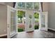 Bright living room featuring french doors that open to a cozy balcony overlooking manicured grounds and lush trees at 128 Steinbeck Way # E, Mooresville, NC 28117