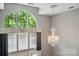 Grand living area showcasing soaring windows, a dazzling chandelier, and elegant neutral tones at 128 Steinbeck Way # E, Mooresville, NC 28117