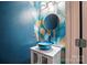 Modern powder room boasts a unique blue glass bowl sink, gold accents, and striking designer wallpaper at 128 Steinbeck Way # E, Mooresville, NC 28117