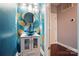 Stylish powder room with blue and gold wallpaper, vessel sink, modern lighting, and sleek fixtures at 128 Steinbeck Way # E, Mooresville, NC 28117