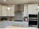 Modern kitchen with white cabinets, gray herringbone tile backsplash, and stainless steel appliances at 14016 Felix Ln # 6, Charlotte, NC 28277
