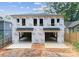 Under construction of a new modern style home with a black roof and two garage doors at 1409 Downs Ave, Charlotte, NC 28205