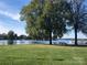 Scenic waterfront view featuring a grassy park, benches, and boats docked in the distance at 16721 Spinnaker Ln, Cornelius, NC 28031
