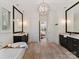 Elegant bathroom featuring dual vanities, soaking tub, chandelier and decorative tile floors at 16733 Reinsch Dr, Davidson, NC 28036