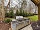 Outdoor kitchen with stainless steel grill and granite countertops in landscaped backyard at 16733 Reinsch Dr, Davidson, NC 28036