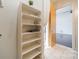 Well-lit hallway features white tiled floors and a closet with shelving near an open doorway at 2116 Mcclintock Rd, Charlotte, NC 28205