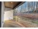 Cozy back porch area with wooden floors, white siding and view of wooded lot at 252 Big Lick Rd, Stanfield, NC 28163
