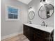 Bathroom featuring a double sink with marble countertops, dark wood cabinets and modern light fixtures at 252 Big Lick Rd, Stanfield, NC 28163