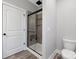Modern bathroom featuring glass shower with seat and matte black trim, toilet and vinyl flooring at 252 Big Lick Rd, Stanfield, NC 28163