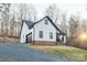 View of the side and rear exterior of a home with dark roof, white siding, and a garage at 252 Big Lick Rd, Stanfield, NC 28163