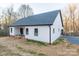 Rear exterior view of a white home with a dark roof and unfinished landscaping at 252 Big Lick Rd, Stanfield, NC 28163