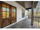 Inviting front porch with wood-look decking, double doors, and black metal railings at 252 Big Lick Rd, Stanfield, NC 28163