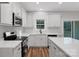 Well-lit kitchen featuring stainless steel appliances, white cabinetry, and wood-look flooring at 252 Big Lick Rd, Stanfield, NC 28163