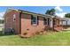Side view of brick ranch home showcasing landscaping and AC unit at 2525 Oxford Cir, Lancaster, SC 29720