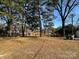 Large backyard with mature trees and a wooden fence at 4513 Munsee St, Charlotte, NC 28213