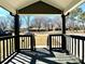 Covered front porch featuring wood decking, railings, and a view of the street at 4513 Munsee St, Charlotte, NC 28213