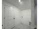 Simple laundry room with white door and marble flooring at 4513 Munsee St, Charlotte, NC 28213