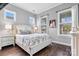 Comfortable bedroom featuring hardwood floors and bright, natural light from multiple windows at 4998 Looking Glass Trl, Denver, NC 28037