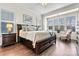 Bright main bedroom with a large bed, drawers, and a seating area by the window at 4998 Looking Glass Trl, Denver, NC 28037