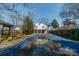 The backyard features a covered pool, wooden fence, and the back of the house with a deck at 531 Elm St, Salisbury, NC 28144